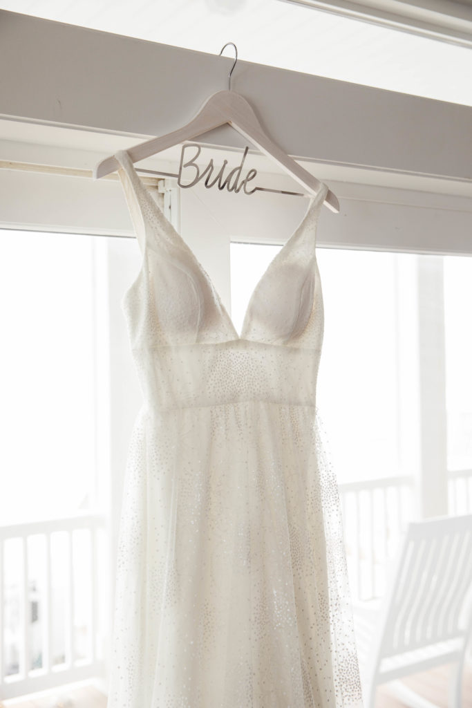 wedding dress hanging in window on custom 'bride' hanger