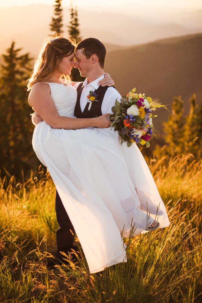 groom holding bride during sunset bridals at mountain top elopement
