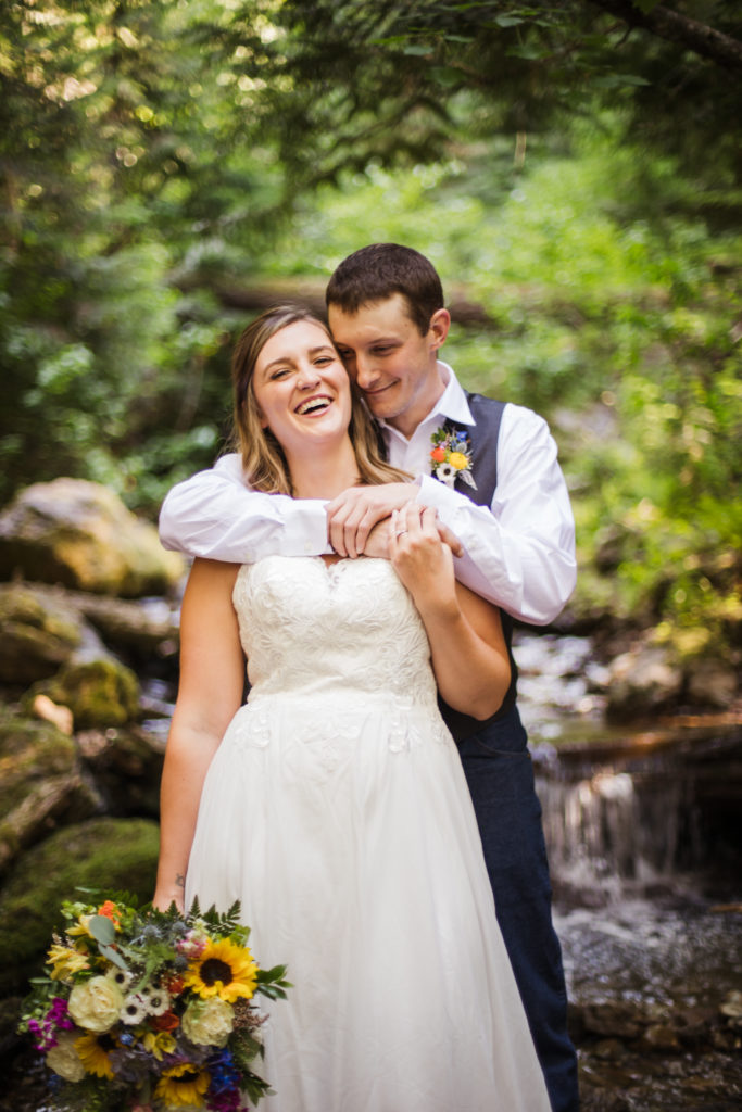 bride and groom embracing and laughing while celebrating recent mountain top elopement