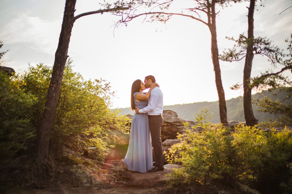 man and woman kissing in trees on fall creek falls engagement session