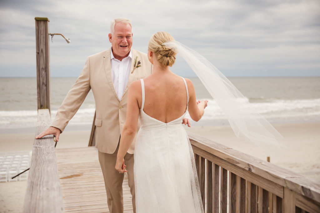 dad smiling and crying seeing daughter on wedding day in wedding dress 