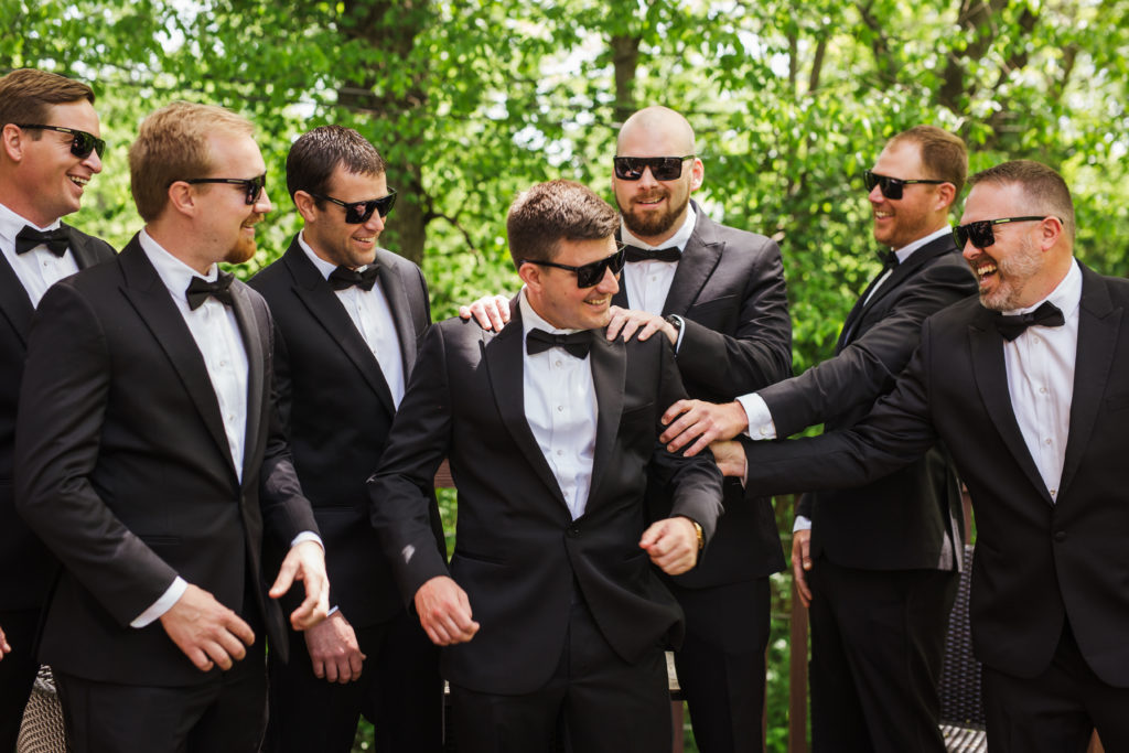 groom and groomsmen wearing sunglasses celebrating