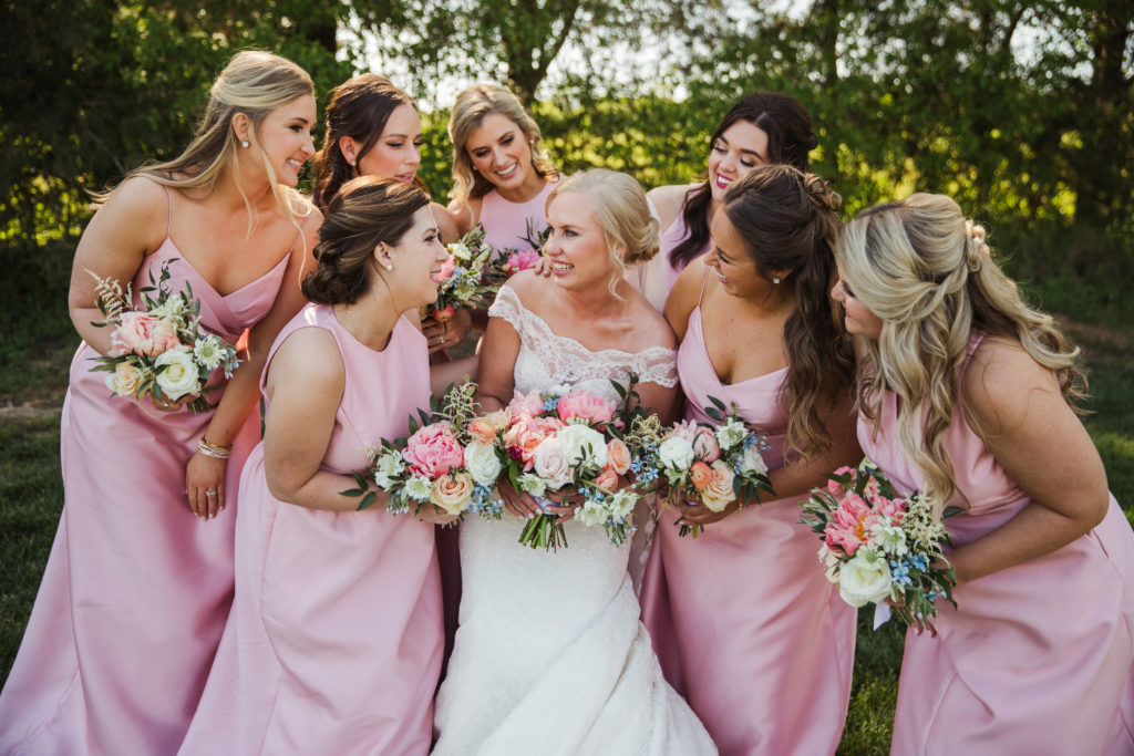 bride and bridal party laughing and celebrating together at barn at sycamore farms wedding