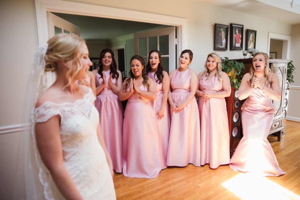 bride during first look with bridesmaids on wedding day