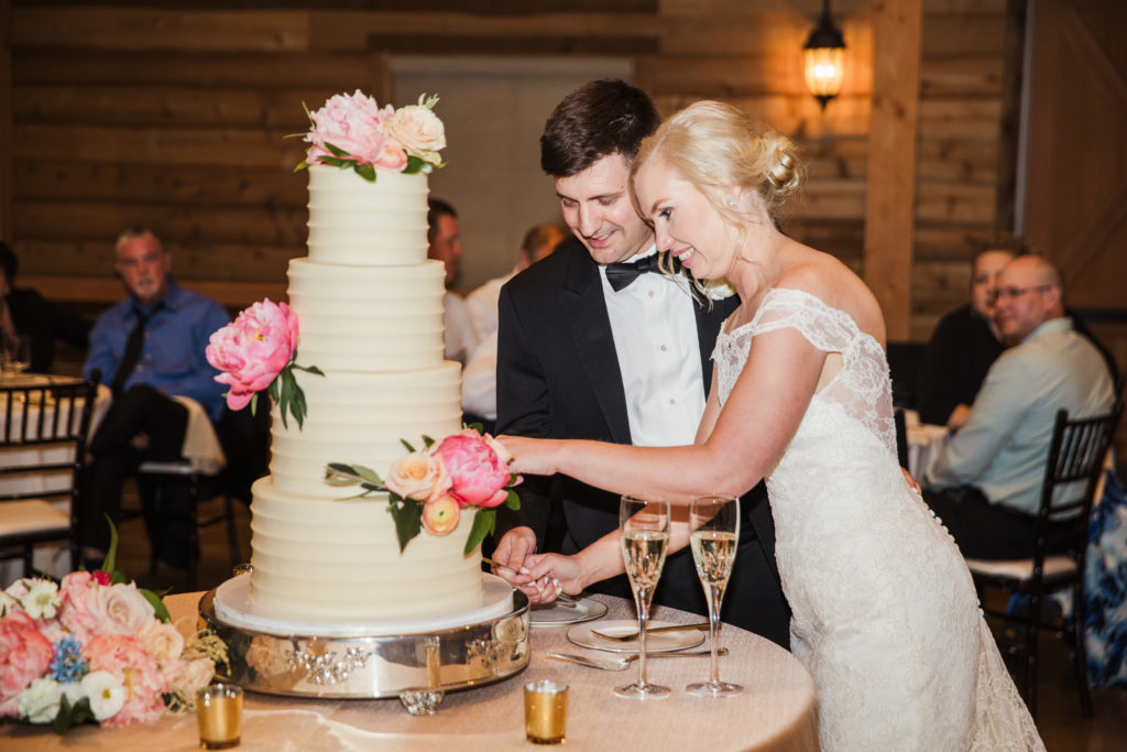 bride and groom cutting wedding cake at barn at sycamore farms wedding