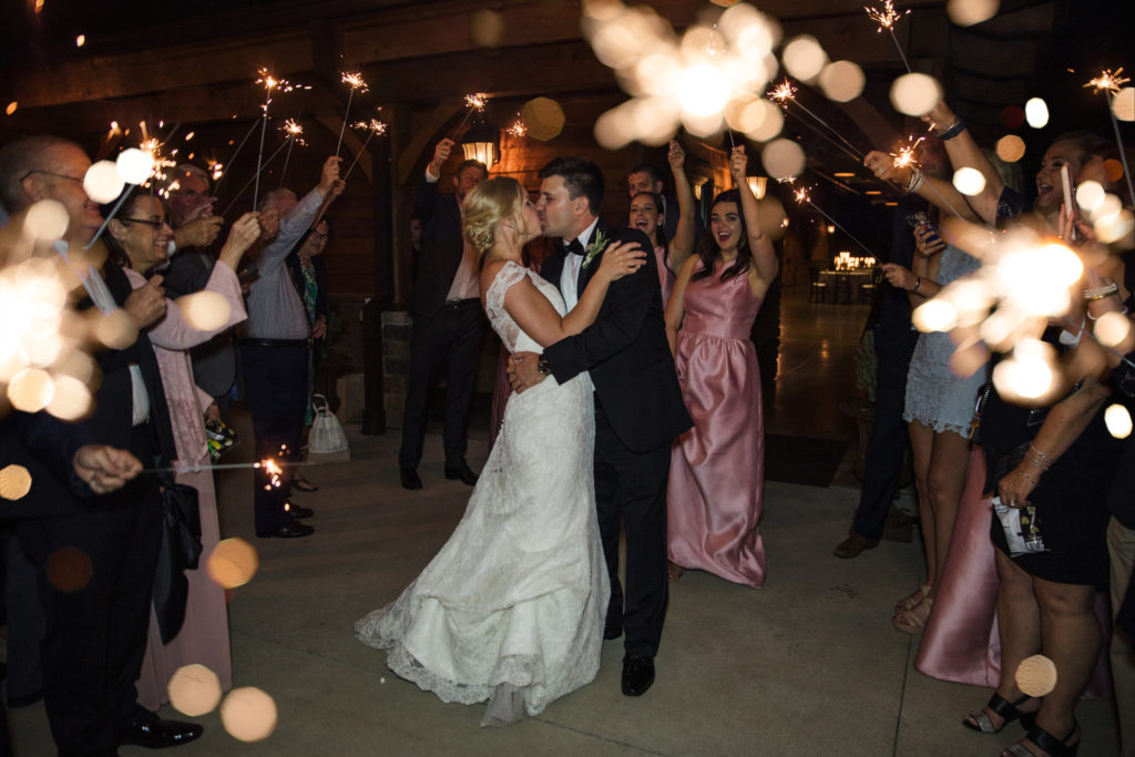 newly married couple exiting wedding reception during sparkler exit