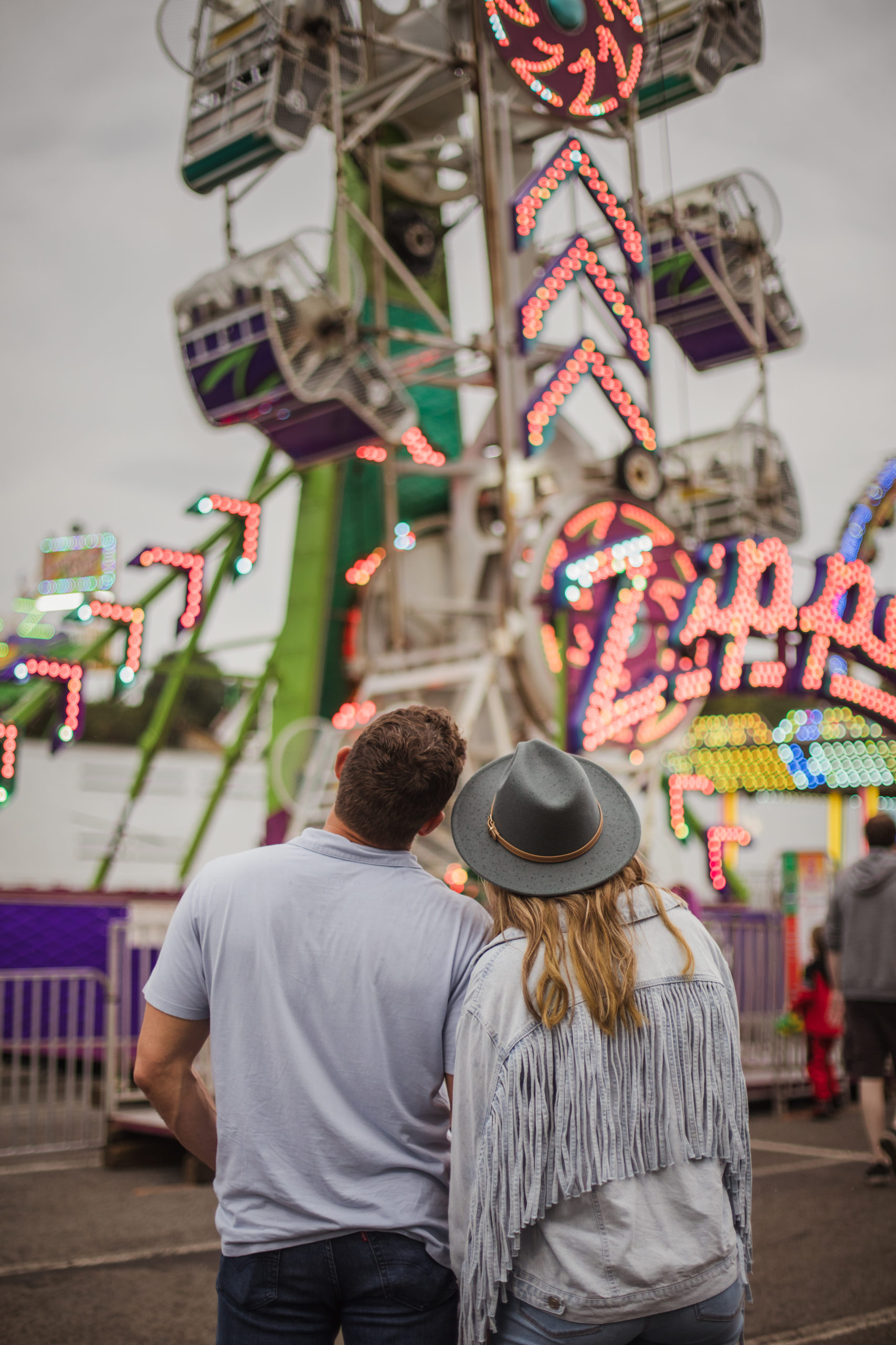 man and woman holding hands watching carousel at Tennessee Valley fair session