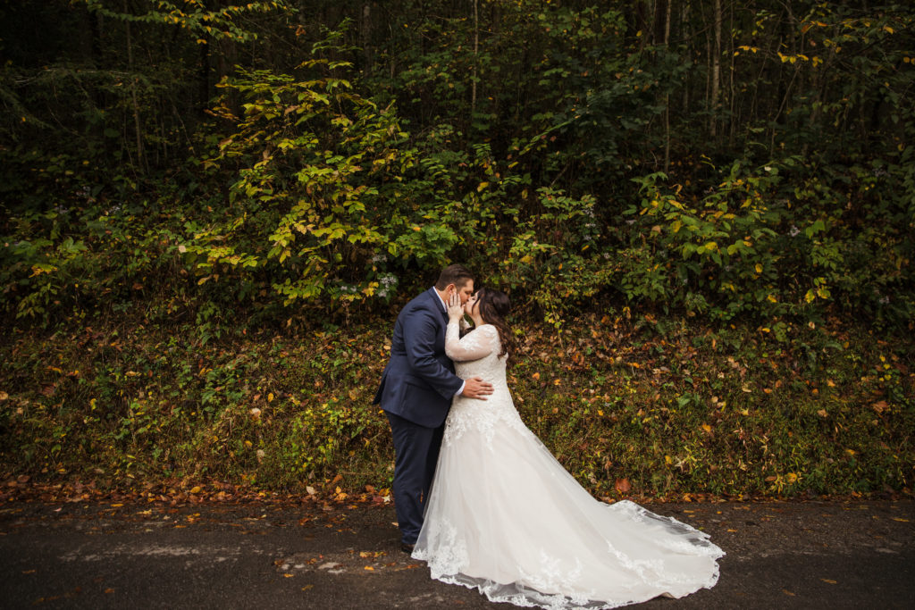 bride and groom kissing during outdoor forest bridals in Smoky Mountain elopement as they plan to honeymoon where you elope