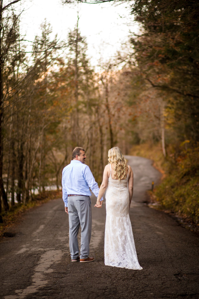 bridal couple walking away holding hands during outdoor bridal portraits