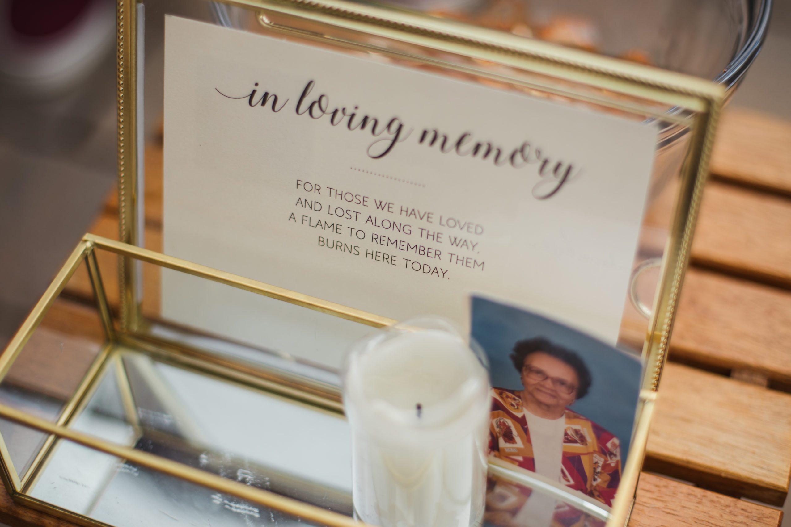 a framed picture honoring loved ones on your wedding day with a candle