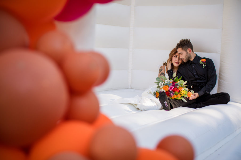 bride and groom cuddling in bounce house