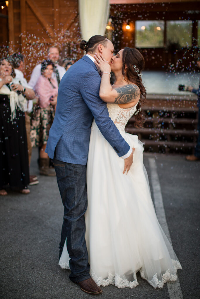 couple kissing during bubble exit, wedding exit