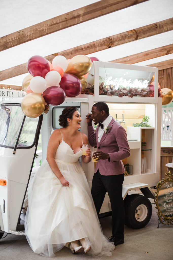 bride and groom in front of drink vendor truck