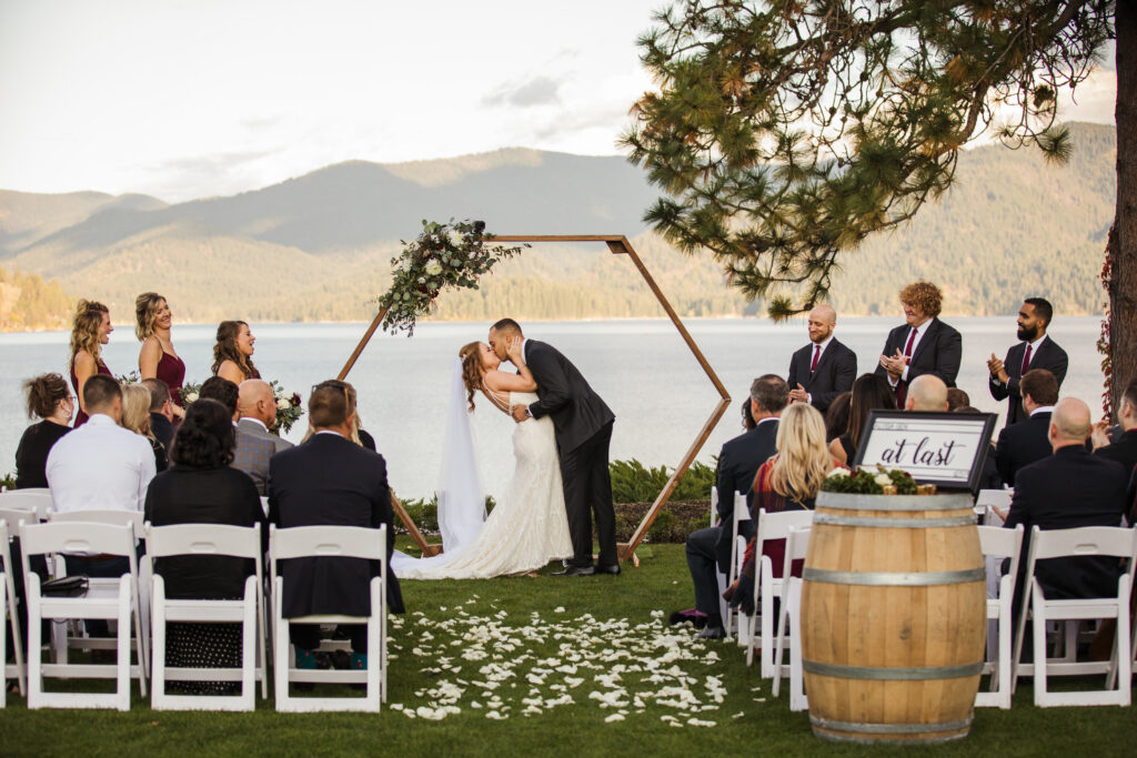 Coeur d’Alene elopement, bride and grooms first kiss with lake view